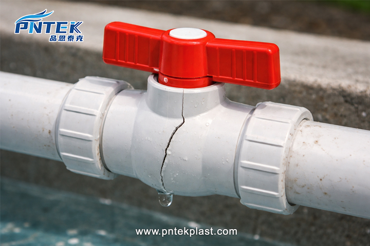 Cracked PVC Valve Body Failure A close-up photograph showing a visible hairline crack on the body of a white PVC valve