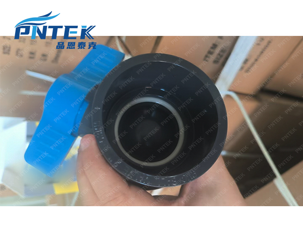 Primer plano de una válvula de bola de PVC instalada