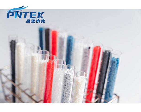 A Pntek engineer holding a raw pellet of polypropylene next to a finished PP valve
