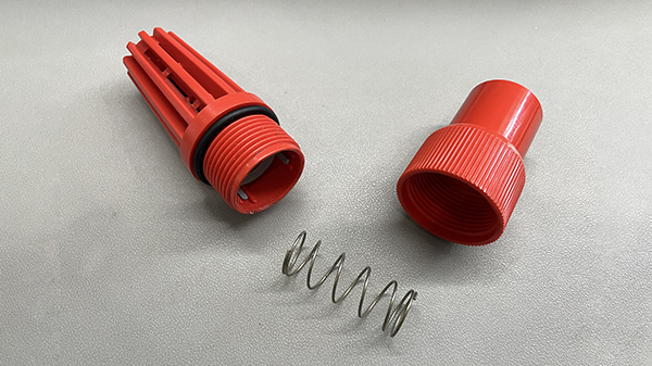 A PVC spring check valve shown with an arrow indicating flow direction