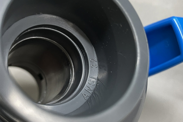 A close-up of the size marking (e.g., 1 inch) embossed on the body of a PVC ball valve
