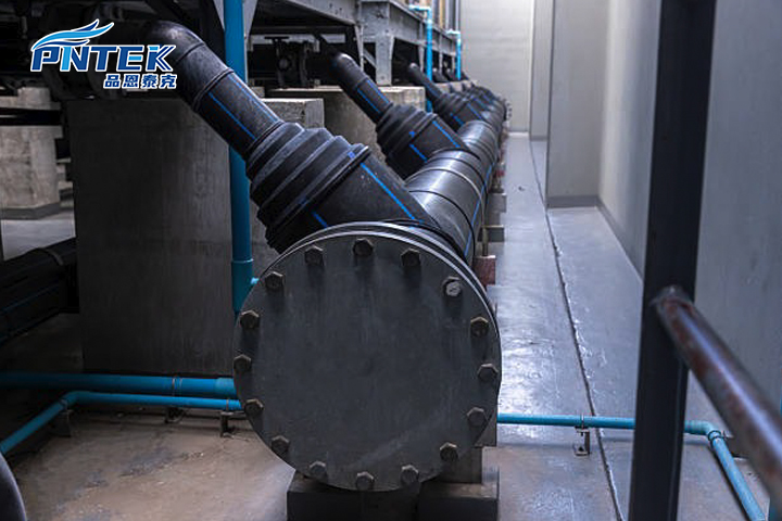 An industrial plant setting showing a complex system of grey PP pipes and fittings