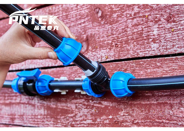 A Pntek PP compression fitting being installed on a PE pipe in a field