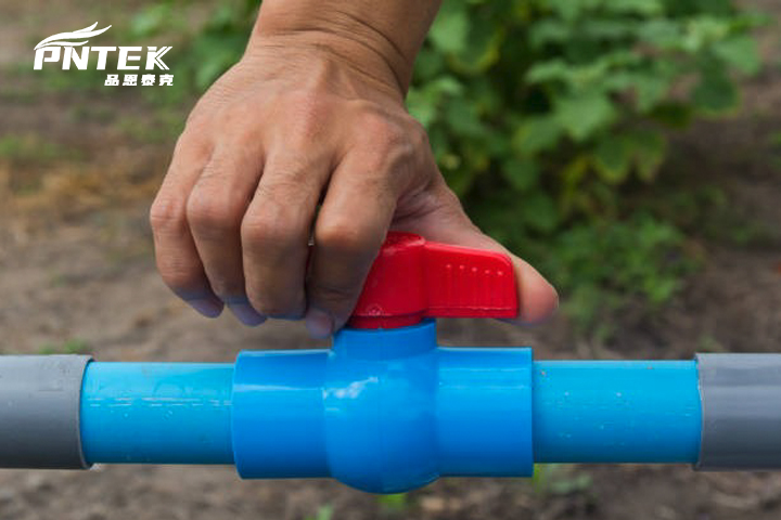 Una mano operando fácilmente una válvula de bola de PVC de un cuarto de vuelta