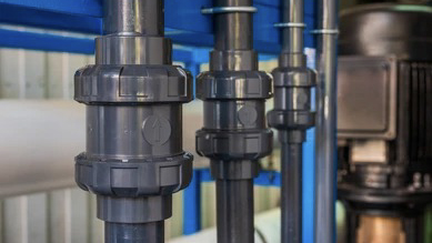 A PVC swing check valve installed near a sump pump to prevent backflow