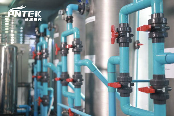 Drywall ilə örtülməzdən əvvəl tam yığılmış PVC boru sistemindəki təzyiqölçəni yoxlayan bir plumber