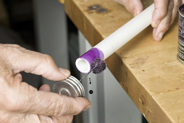 A professional correctly installing a Pntek true union PVC ball valve on a white PVC pipe