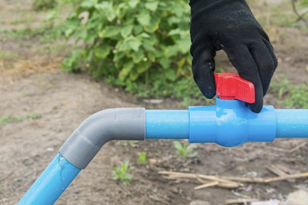 A PVC ball valve installed in a pipe, isolating a water pump for maintenance