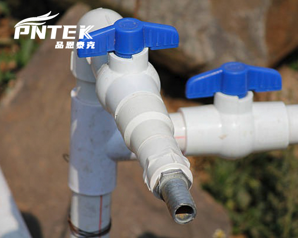 Primer plano de una válvula de PVC con una fuga visible