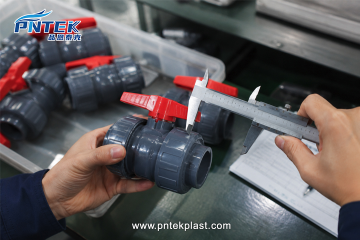 Testing PVC Valve Samples a close-up shot of hands measuring a PVC valve with calipers