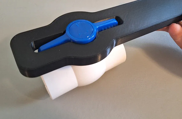 A person correctly using channel-lock pliers on a PVC valve handle